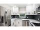 Modern kitchen with white cabinets, stainless steel appliances and quartz countertops at 639 Shore Acres Dr, Lakeland, FL 33801