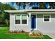 Front view of a charming house with a blue door and well-manicured lawn at 639 Shore Acres Dr, Lakeland, FL 33801