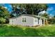 Gray house with a grassy lawn and mature trees in the background at 639 Shore Acres Dr, Lakeland, FL 33801