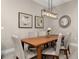 Elegant dining room with a wood table, six chairs, and a modern light fixture at 7585 Sunny Dreams Ln, Kissimmee, FL 34747