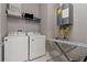 Laundry room with washer, dryer, ironing board, and shelving at 7585 Sunny Dreams Ln, Kissimmee, FL 34747
