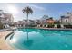 Sparkling community pool with palm trees and lounge chairs at 7585 Sunny Dreams Ln, Kissimmee, FL 34747