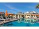 Community pool with plenty of lounge chairs and umbrellas at 7585 Sunny Dreams Ln, Kissimmee, FL 34747