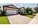 One-story house with a white garage door and lush landscaping at 7845 Wandering Way, Orlando, FL 32836