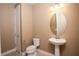 Clean bathroom with pedestal sink, toilet and oval mirror at 7845 Wandering Way, Orlando, FL 32836