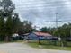 Blue house with red roof, gated driveway, and several vehicles at 1808 S Tanner Rd, Orlando, FL 32820