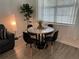 Modern round dining table with four black chairs and wood-look floors at 2971 Camden Way, Davenport, FL 33837