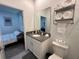 Modern bathroom with gray vanity, walk-in shower, and white toilet at 2971 Camden Way, Davenport, FL 33837