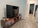 Living area with TV stand, view into kitchen, and wood-look floors at 2971 Camden Way, Davenport, FL 33837