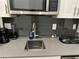 Modern kitchen sink and countertop with gray tile backsplash at 2971 Camden Way, Davenport, FL 33837