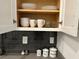 White kitchen cabinets filled with dishes and other items at 2971 Camden Way, Davenport, FL 33837