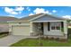 One-story house with gray siding, a two-car garage, and a landscaped yard at 2971 Camden Way, Davenport, FL 33837
