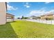 Large grassy backyard with a white vinyl fence and covered patio at 3804 Marietta Way, St Cloud, FL 34772