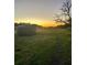 Sunset over a tranquil farmland with a water tank at 8836 Sr 471 Hwy, Webster, FL 33597
