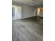 Living room with grey wood-look flooring and sliding door to patio at 1025 S Hiawassee Rd # 2216, Orlando, FL 32835