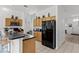 Modern kitchen with wood cabinets, black appliances and kitchen island at 131 Cadiz Loop, Davenport, FL 33837