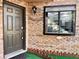 Condo entry with dark brown door, window, and landscaping at 1734 Foxhall Cir # 1734, Kissimmee, FL 34741