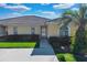 Front view of a villa with a red door and green lawn at 2216 Mystic Ring Loop, Poinciana, FL 34759