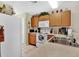 Cozy kitchen featuring wood cabinets, white appliances, and double sink at 2216 Mystic Ring Loop, Poinciana, FL 34759