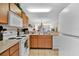 Kitchen with white appliances and wood cabinets at 2216 Mystic Ring Loop, Poinciana, FL 34759
