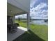 Covered patio overlooking a lake with seating area and neighborhood views at 2737 Nottel Dr, Saint Cloud, FL 34772
