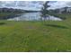 Lakefront property with lush green grass and houses reflecting on the water at 2737 Nottel Dr, Saint Cloud, FL 34772