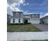 Two-story home with a gray and purple exterior, two-car garage, and manicured lawn at 2737 Nottel Dr, Saint Cloud, FL 34772