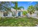 One-story light blue home with palm trees and a two-car garage at 3232 Lorimar Ln, Saint Cloud, FL 34772