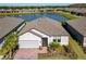 Single-story home with a gray roof and brick driveway, situated on a lake at 445 Via Abruzzi St, Poinciana, FL 34759