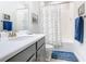 Bathroom with shower/tub combo, gray vanity, and white tile at 445 Via Abruzzi St, Poinciana, FL 34759