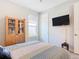 Comfortable bedroom with mounted TV, wood cabinet, and ceiling fan at 445 Via Abruzzi St, Poinciana, FL 34759