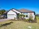 Single-story house with gray siding, landscaping, and a two-car garage at 445 Via Abruzzi St, Poinciana, FL 34759