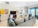 Living room features a sectional sofa, large TV, and access to an outdoor patio at 445 Via Abruzzi St, Poinciana, FL 34759