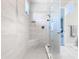 Walk-in shower with glass door, built-in seat, and neutral tile at 445 Via Abruzzi St, Poinciana, FL 34759