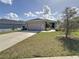 House exterior features a two car garage and well maintained lawn at 502 Pentas Ln, Haines City, FL 33844