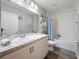 Bathroom with a bathtub, shower, and a nautical-themed vanity at 502 Pentas Ln, Haines City, FL 33844