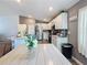 Modern kitchen with white cabinets, farmhouse table, and stainless steel appliances at 502 Pentas Ln, Haines City, FL 33844