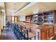 Long bar with wood finishes and barstools at 141 Marabella Loop, Poinciana, FL 34759