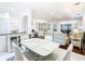 Spacious dining area with a glass table, white chairs, and views into the living room and kitchen at 141 Marabella Loop, Poinciana, FL 34759