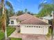 House exterior showcasing a two-car garage and well-maintained lawn at 141 Marabella Loop, Poinciana, FL 34759