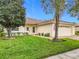 House exterior showing a well-maintained lawn, garage, and palm trees at 141 Marabella Loop, Poinciana, FL 34759