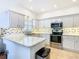 Modern kitchen with stainless steel appliances and light gray cabinets at 141 Marabella Loop, Poinciana, FL 34759