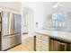 Kitchen boasts stainless steel appliances and white cabinets, with views into the breakfast area at 141 Marabella Loop, Poinciana, FL 34759