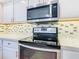 Close-up of the cooktop and microwave in the kitchen at 141 Marabella Loop, Poinciana, FL 34759