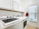 Bright laundry room, featuring washer, dryer, and cabinets at 141 Marabella Loop, Poinciana, FL 34759