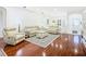 Relaxing living room with hardwood floors, light-colored sofas, and a large area rug at 141 Marabella Loop, Poinciana, FL 34759