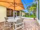 Relaxing patio with seating area, umbrella, and screened enclosure at 141 Marabella Loop, Poinciana, FL 34759