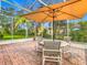 Relaxing screened patio with patio furniture and shade umbrella at 141 Marabella Loop, Poinciana, FL 34759