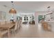 Open concept dining room with light wood table and view into living room and kitchen at 356 Citrine Loop, Kissimmee, FL 34758