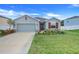 Gray house with red shutters, two-car garage, and landscaped lawn at 356 Citrine Loop, Kissimmee, FL 34758